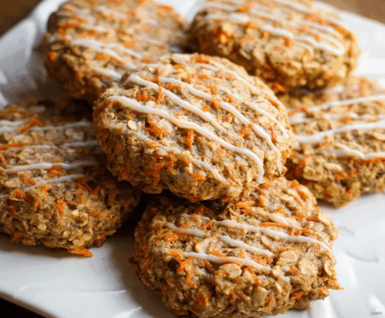 Delicious homemade carrot cake oatmeal cookies with grated carrots, walnuts, and creamy frosting on top, perfect for a healthy dessert or snack.