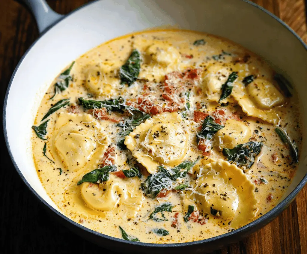 Creamy Tuscan Ravioli Soup with spinach, sun-dried tomatoes, and grated Parmesan cheese in a bowl