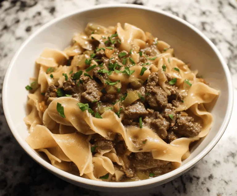 Delicious homemade stovetop beef and noodles served in a bowl with tender beef slices and creamy noodles garnished with herbs