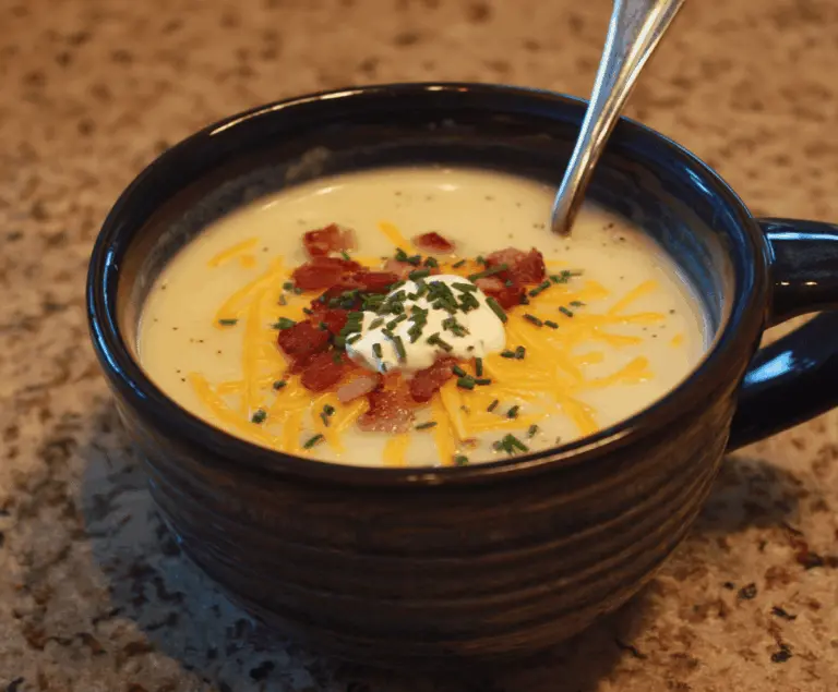 Creamy Outback Steakhouse Potato Soup served in a bowl with fresh herbs and crispy bread on the side, perfect for a comforting meal.