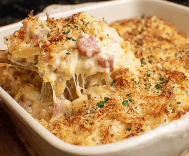 Delicious Chicken Cordon Bleu Casserole topped with melted cheese and crispy golden breadcrumbs, served hot on a white plate
