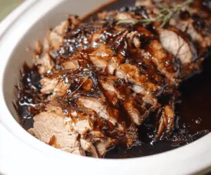 Juicy Crockpot brown sugar balsamic glazed pork tenderloin served with fresh vegetables on a white plate