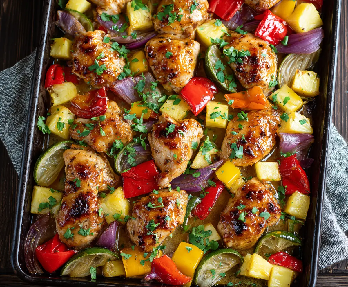 Delicious Hawaiian Chicken Sheet Pan with grilled pineapple, bell peppers, and seasoning on a baking sheet.