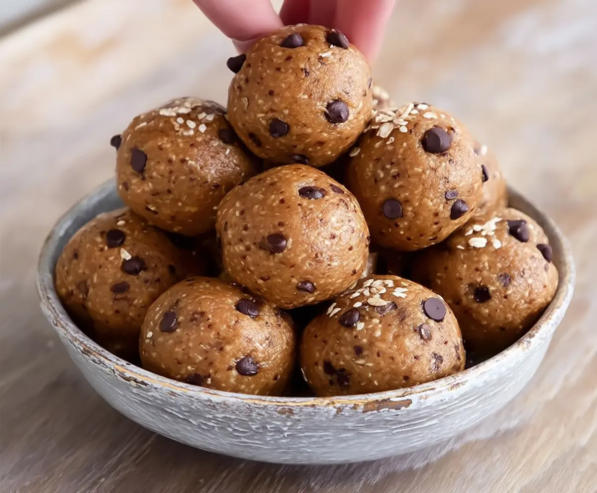 Healthy homemade Kodiak Cakes protein balls on a white plate with nuts and berries