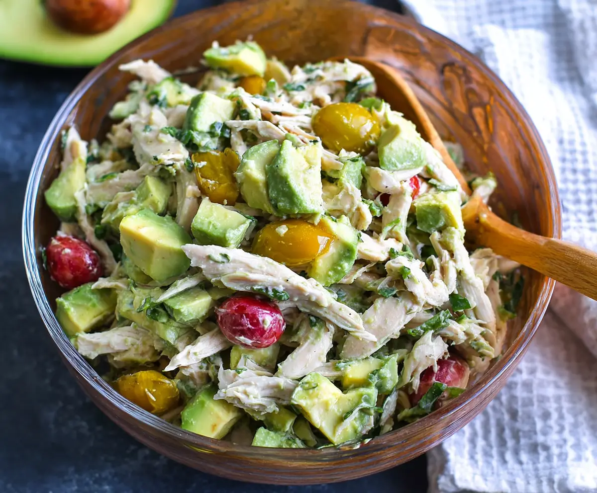 Creamy and nutritious avocado chicken salad with fresh vegetables and herbs, perfect for a healthy lunch or snack.