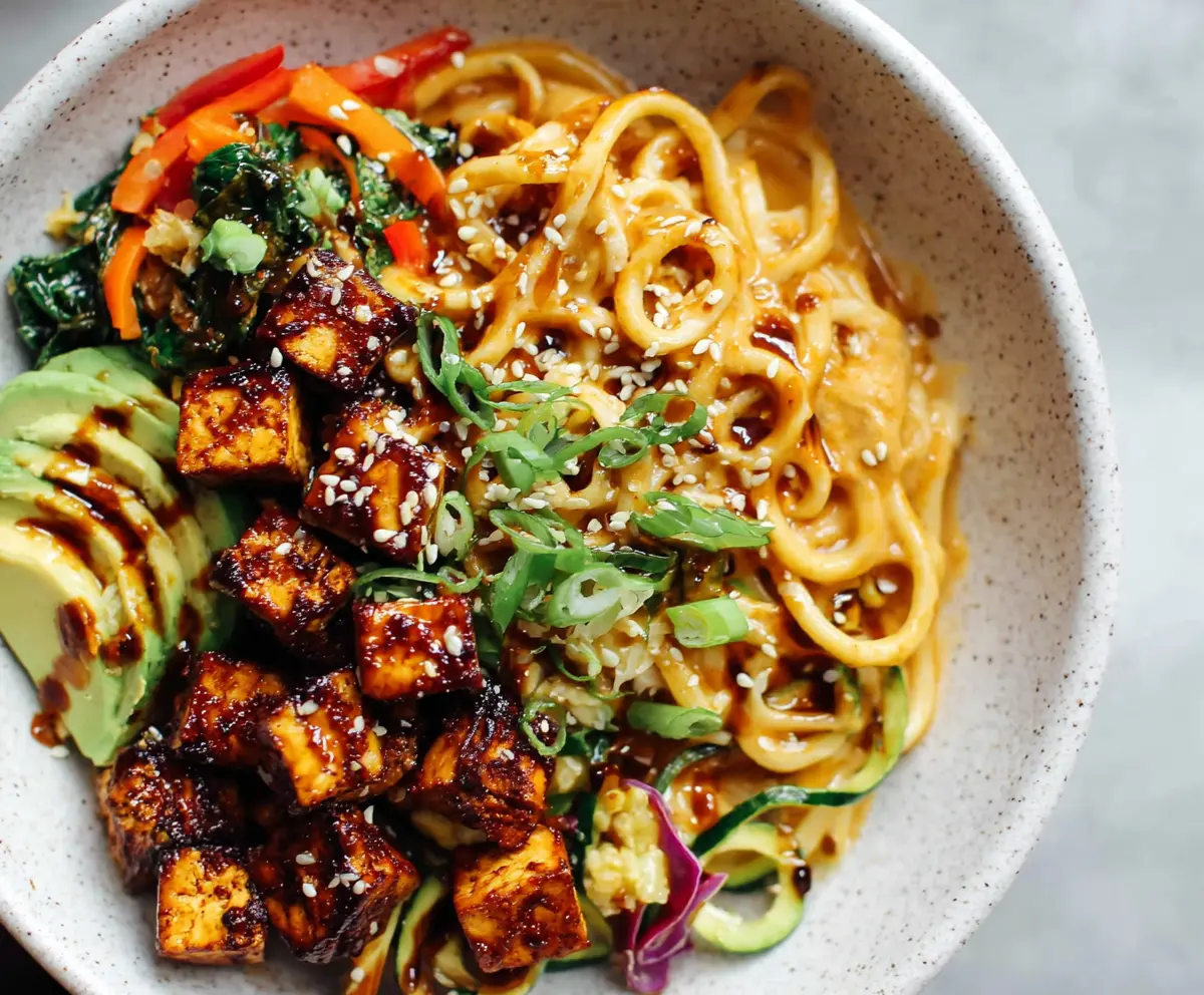Healthy Sesame Noodle Tofu Bowl with fresh vegetables and crunchy toppings.