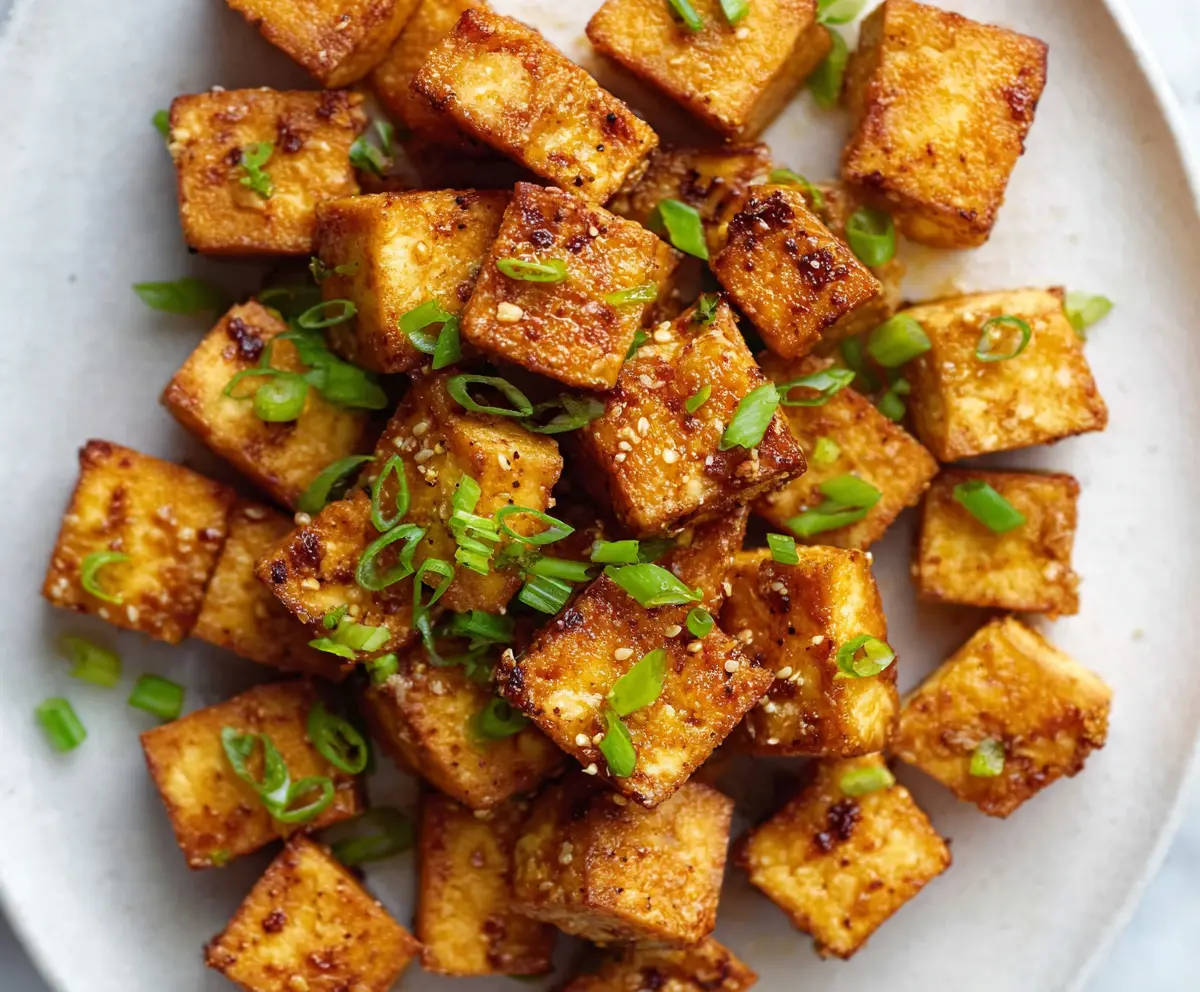 Crispy Air Fryer Tofu served on a white plate with a side of vegetables